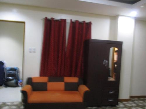 a living room with a couch and red curtains at WMV Hotel & Restaurant in Infanta