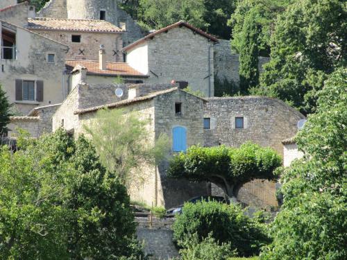 an old house with a blue door in a village at Le Mas des Restanques in Le Poët-Laval