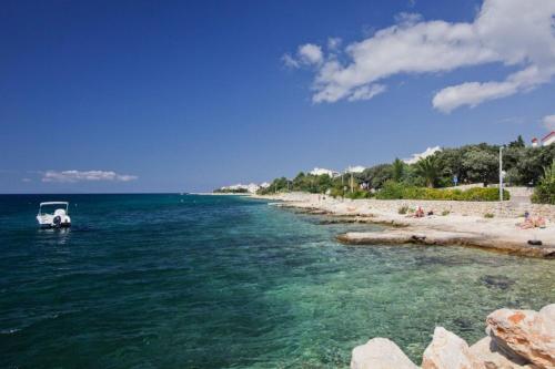a boat in the water next to a beach at Apartments Elia in Mandre