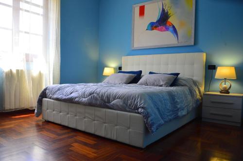 a bedroom with a large bed with a blue wall at B&B Villa Elisa in Bosa