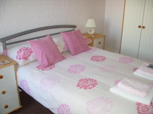 a pink and white bed with pink pillows at The Croydon in Blackpool