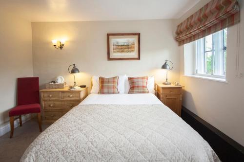 a bedroom with a large bed and two windows at The Conigre in Melksham