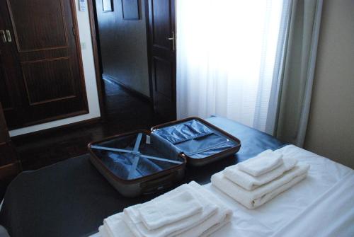 ポンタ・デルガダにあるApartamentos do Teatroのテーブルにオープンスーツケースを用意しています。