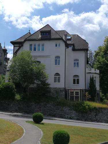 a large white house on the side of a road at Stilvolle 3-Zimmer Wohnung in Jugendstilvilla in Flims
