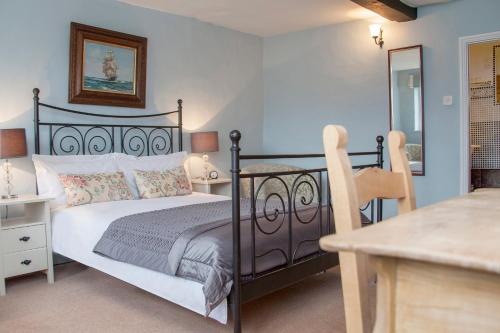 a bedroom with a black bed and a table at The Conigre in Melksham