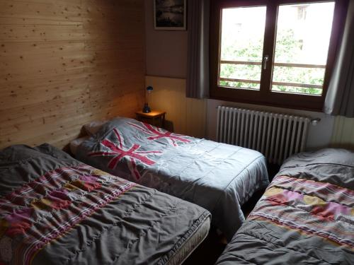 two beds sitting in a room with a window at Chalet Le Bois Noir in Valdeblore