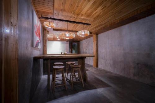 a kitchen with a bar with stools and a mirror at Ganesh Villa in Ubud