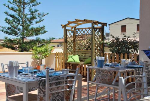 a patio with tables and chairs and a gazebo at B&B Mare e Templi in Agrigento