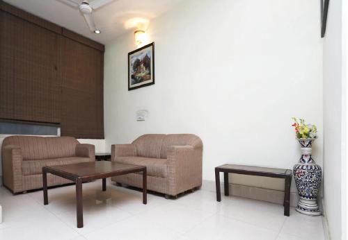 a waiting room with two chairs and a vase of flowers at Hotel Dreamz Residency in Karnāl