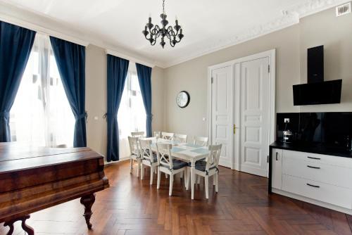 a dining room with a table and a piano at Wilhelmstadt Apartment 90m - PARKING in Toruń