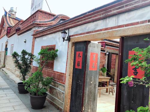an old building with plants on the side of it at 心琴古厝包棟民宿 in Jinning