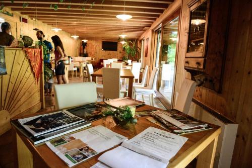a table with books and papers on it in a restaurant at BioAgriturismo Vegan Campo di Cielo in Cesiomaggiore