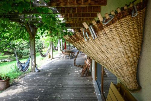 a covered walkway with wicker chairs and tables at BioAgriturismo Vegan Campo di Cielo in Cesiomaggiore