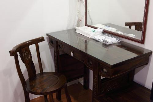 a wooden desk with a mirror and a chair at Long Shan Hotel in Jiaoxi