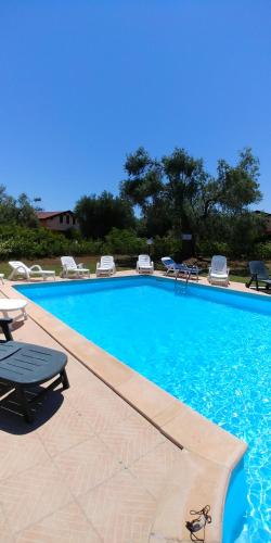 a large swimming pool with chairs and a table at La Piana degli Ulivi in Rossano