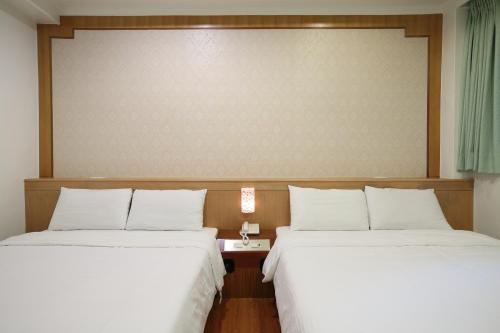 two beds sitting next to each other in a room at Long Shan Hotel in Jiaoxi