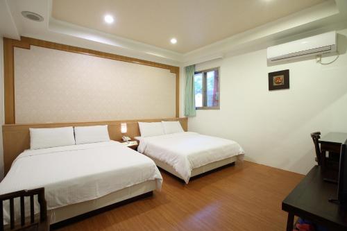 a bedroom with two beds and a projector screen at Long Shan Hotel in Jiaoxi