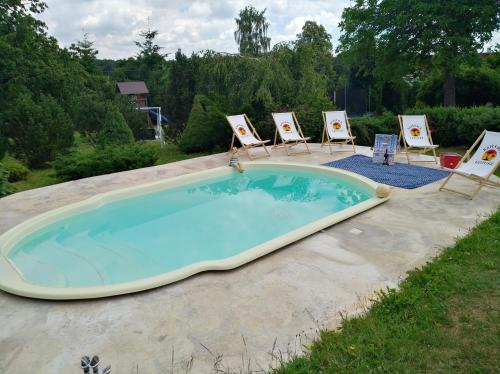 una gran piscina con sillas y una piscina en Apartmán U Mluvících Kamenů, en Staré Křečany