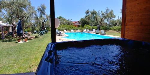 a bath tub with a swimming pool in a yard at La Piana degli Ulivi in Rossano