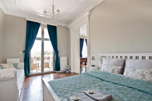 a bedroom with a bed with a green comforter and a window at Wilhelmstadt Apartment 90m - PARKING in Toruń