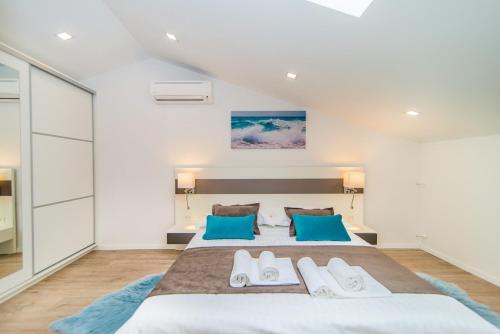 a bedroom with a large bed with blue pillows at Milohanic Luxury Apartments in Poreč