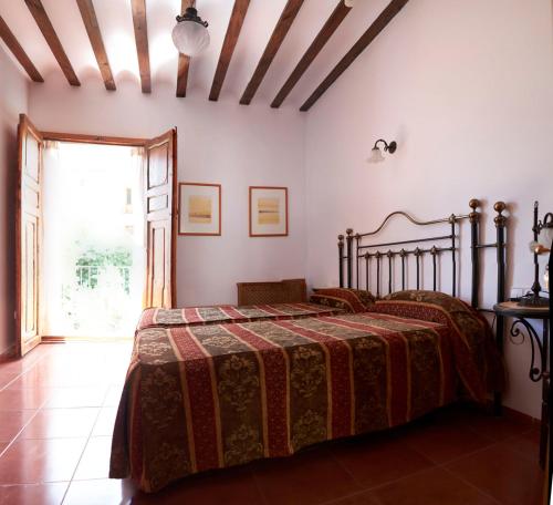 a bedroom with a bed in a room with a window at Hotel Casa de los Arcos in Vélez Blanco