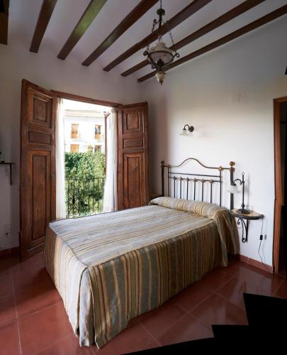 a bedroom with a bed in a room with a window at Hotel Casa de los Arcos in Vélez Blanco