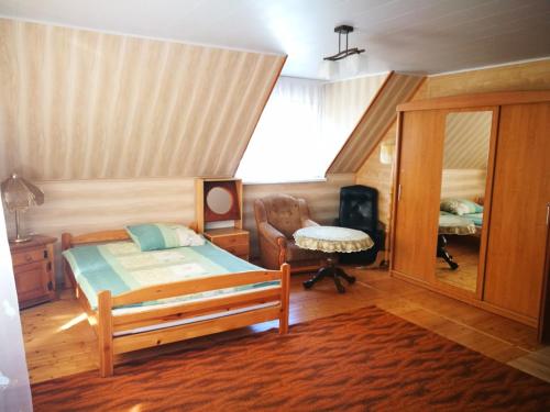 una camera con letto, sedia e specchio di Agrowczasy u Mirusi a Wiżajny