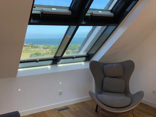 a chair sitting in a room with a large window at Tor zum Meer in Helgoland