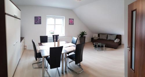 a dining room with a table and black chairs at Apartments Club Telgárt in Telgárt