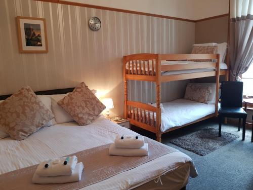 a bedroom with two beds and a bunk bed at Waterfront Hotel in Deal
