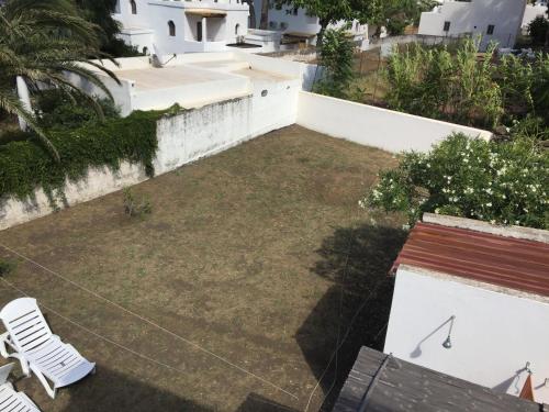 a small backyard with a lawn with two chairs at Casa Galletta in Stromboli