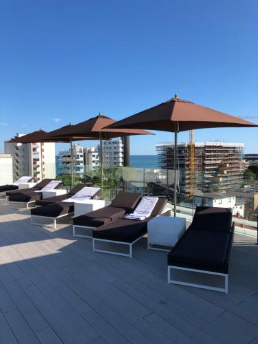 a group of lounge chairs and umbrellas on a roof at Bellini Relais in Lignano Sabbiadoro