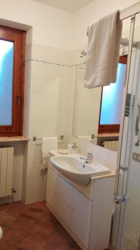 a white bathroom with a sink and a mirror at Sweet Home Casa Vacanze "La Terrazza" in Rovetta