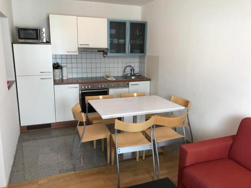 a small kitchen with a white table and chairs at Apartementhaus Helene am Klopeinersee in Unterburg am Klopeiner See