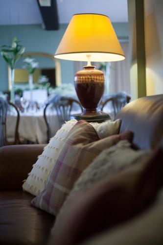 a person laying on a couch with a lamp at The Conigre in Melksham