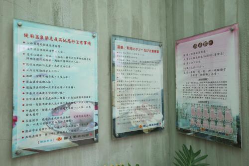 three signs on the side of a wall at Long Shan Hotel in Jiaoxi