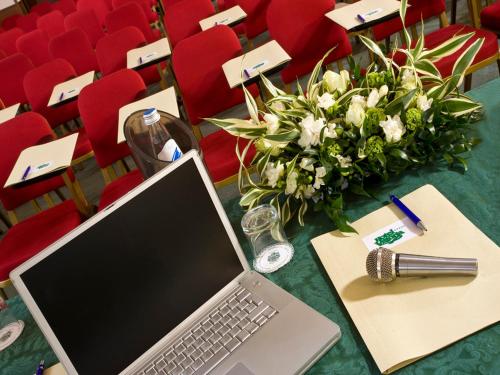 a laptop computer sitting on a table in an auditorium at Hotel Vittoria in Pesaro