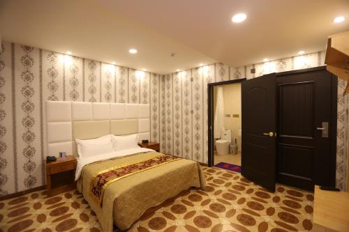 a bedroom with a large bed and a bathroom at Baigal Hotel in Ulaanbaatar
