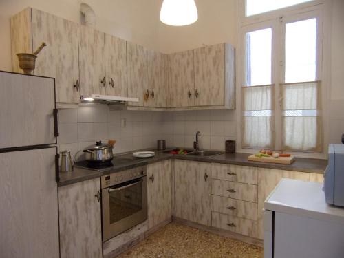 a kitchen with wooden cabinets and a sink at Finestra Rossa old town vintage house in Lefkada Town