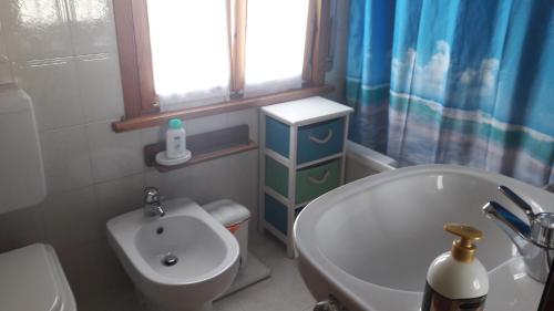 een badkamer met een wastafel, een toilet en een bad bij Residenza Letizia in Nemeggio