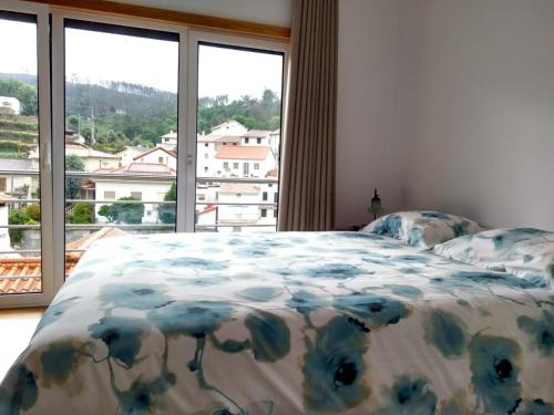 a bedroom with a bed and a large window at Casa D.Dinis in Vide