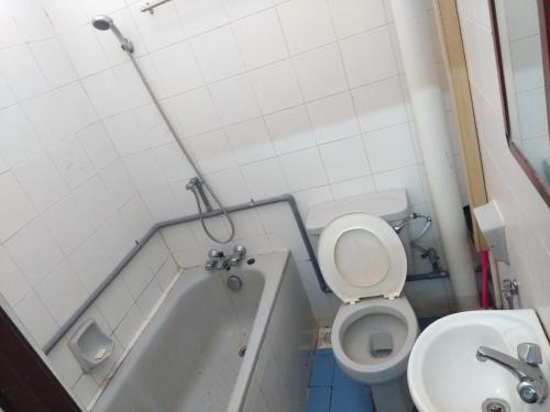 a bathroom with a tub and a toilet and a sink at Seri Lagenda Apartment in Kuah