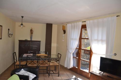 a living room with a dining table and a window at Casa Rural Borda Marianet in Cerler