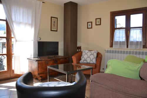 a living room with a couch and chairs and a tv at Casa Rural Borda Marianet in Cerler