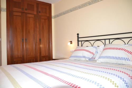 a bedroom with a large bed with red and white pillows at Casa Rural Borda Marianet in Cerler
