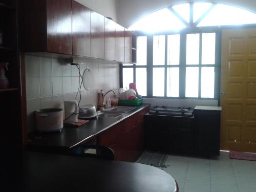a kitchen with wooden cabinets and a counter top at Seri Lagenda Apartment in Kuah