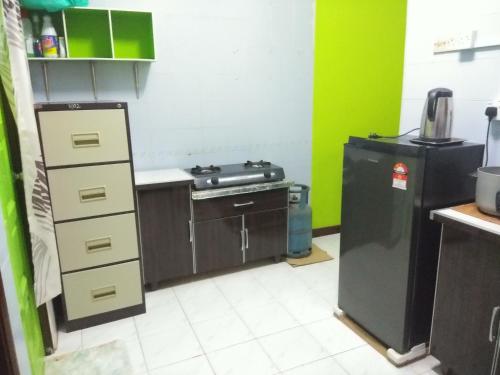 a kitchen with a stove and a refrigerator at Seri Lagenda Apartment in Kuah