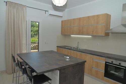 PotamósにあるTilemachos House near Corfu townのキッチン(黒いカウンタートップ、テーブル付)