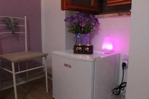 a small refrigerator with a candle and purple flowers on it at B&B Verzavò in Cetraro